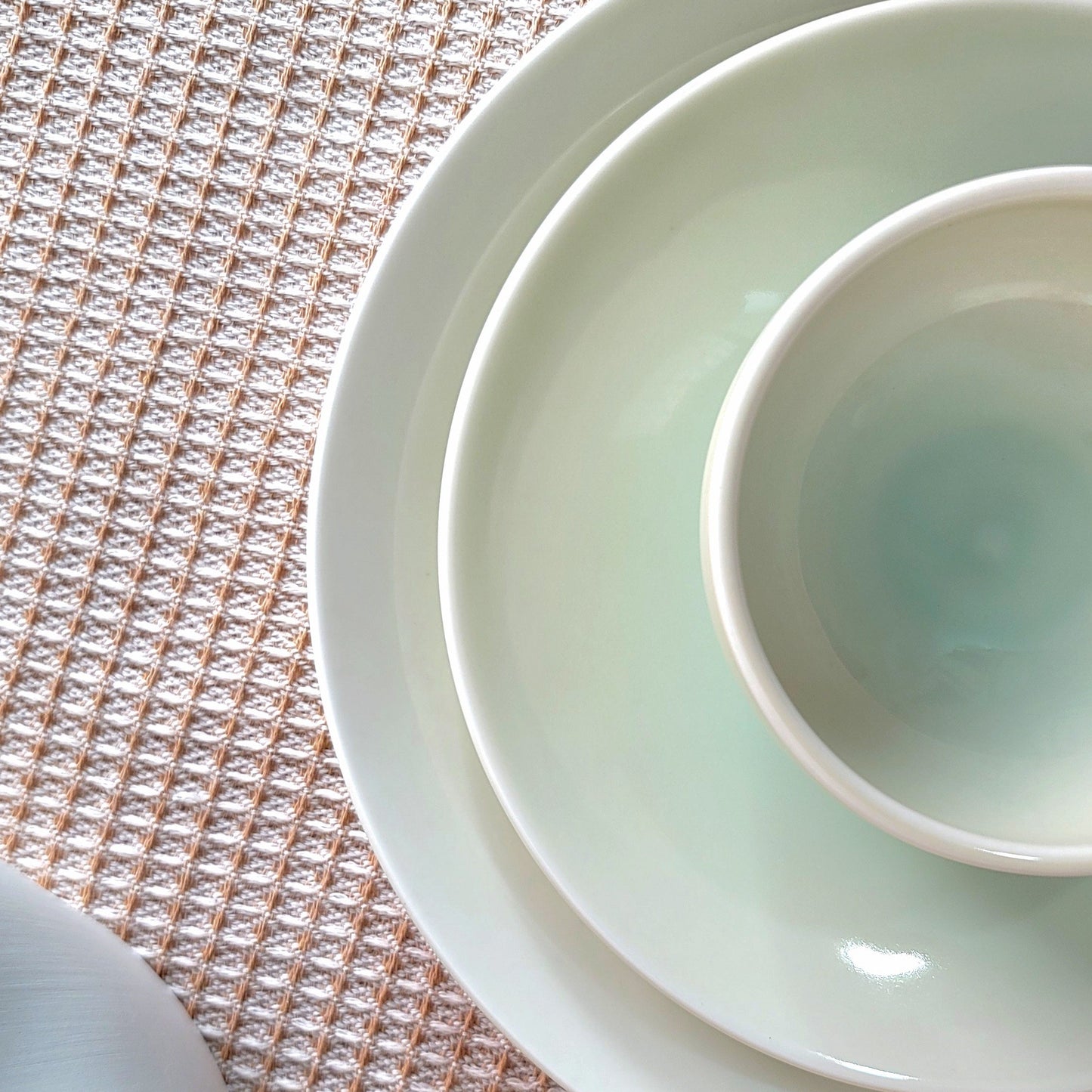 Stack of white ceramic bowls on a textured surface