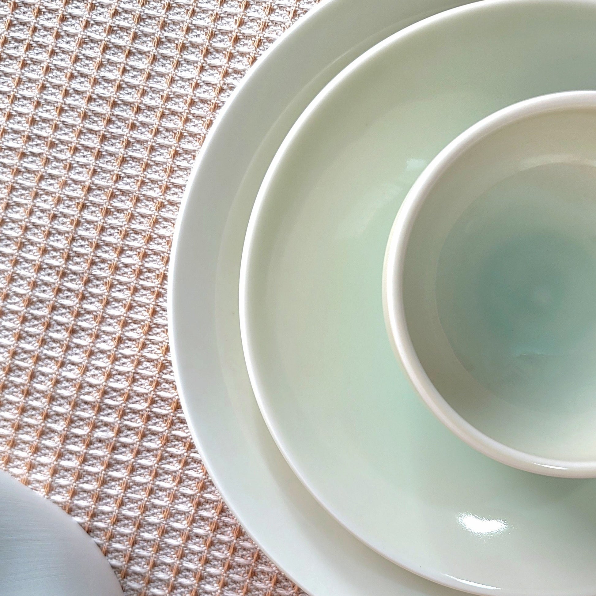 Stack of white ceramic bowls on a textured surface