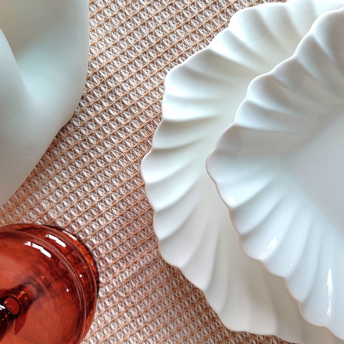 White ceramic dish with scalloped edges on a textured surface