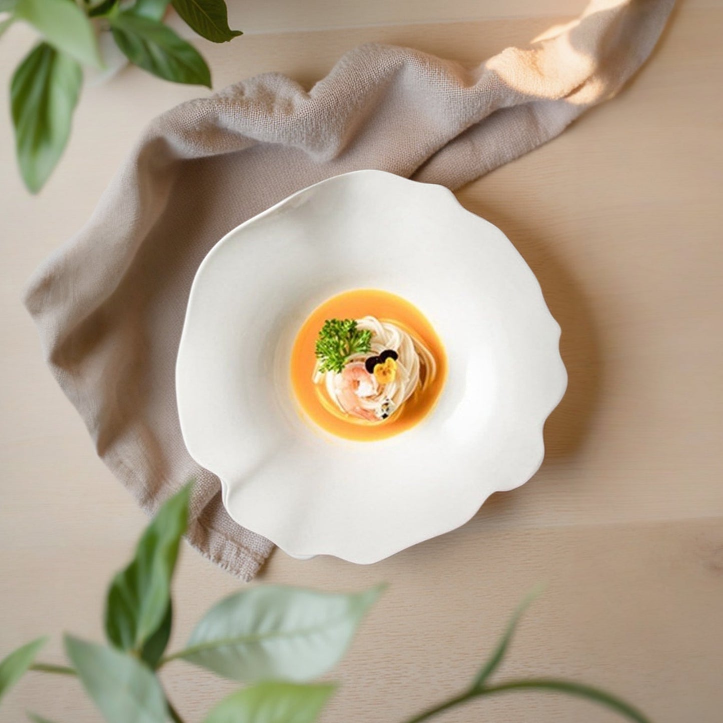 Delicate dish served in a white shell with garnishes, placed on a beige surface with green leaves in the background.