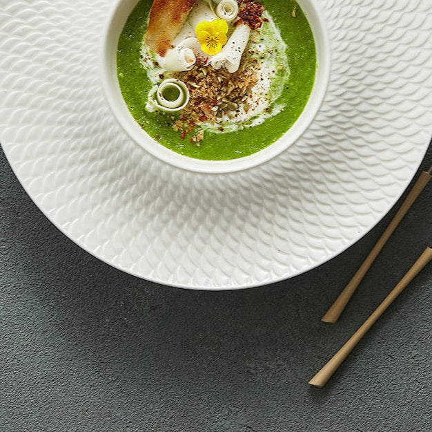 A luxury porcelain presentation plate featuring a deep well ideal for soups, purees, or gourmet plated dishes.