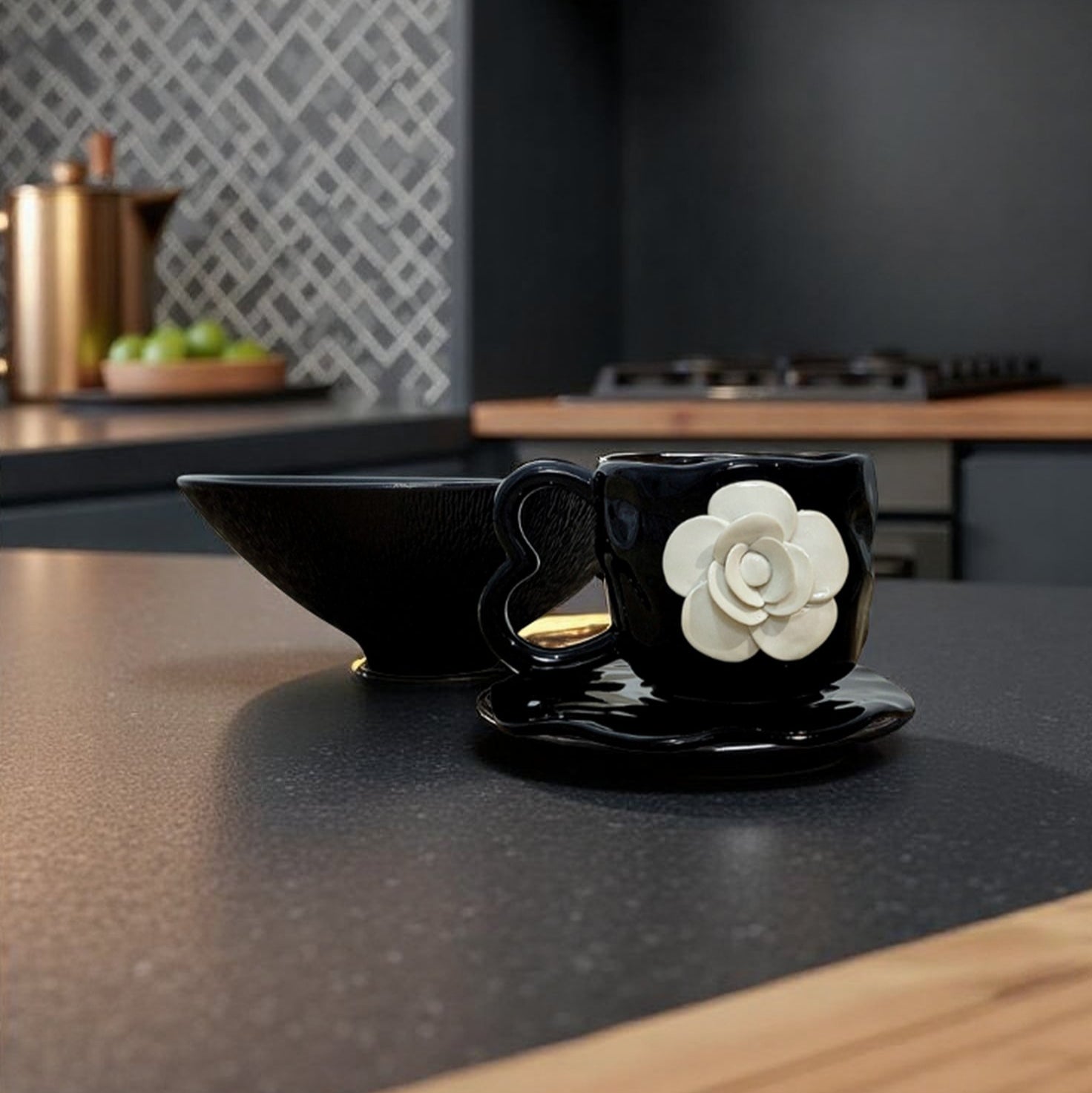 Black cup with white flower design on a saucer on a kitchen counter.