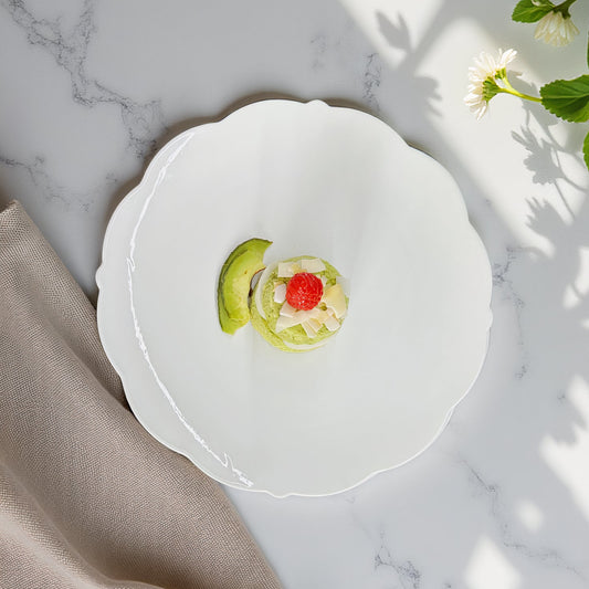 Small dish with a dessert on a marble surface with a beige napkin and flowers.