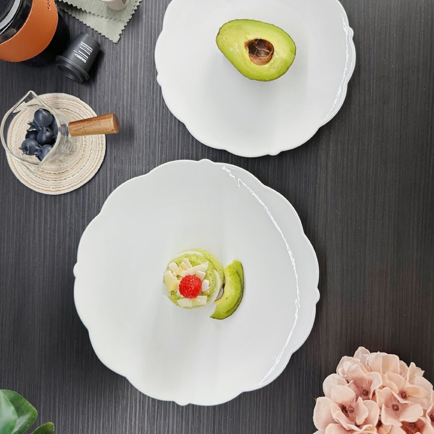 Two white ceramic bowls with decorative elements on a dark surface.