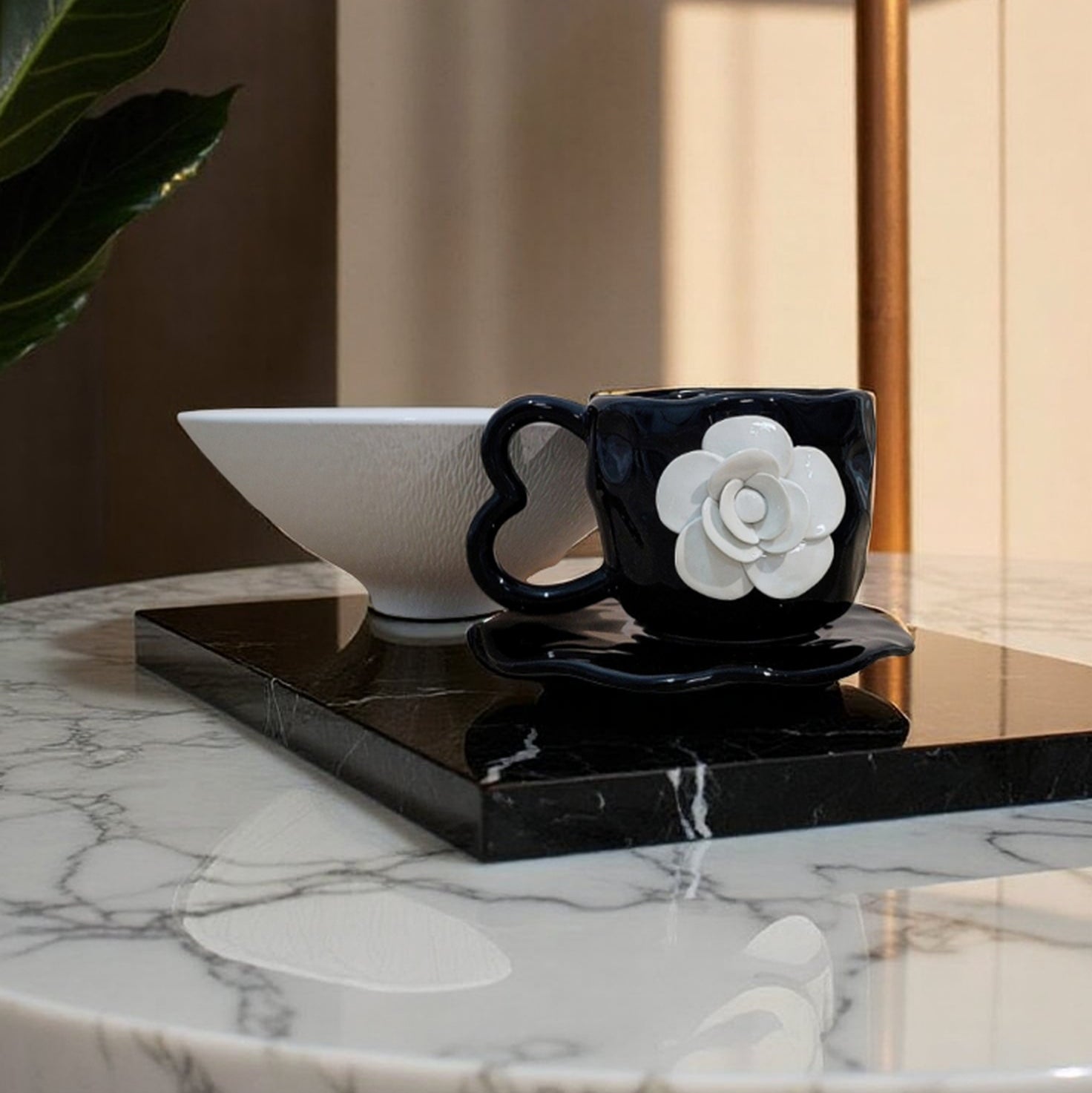 Black mug with white flower design on a marble table